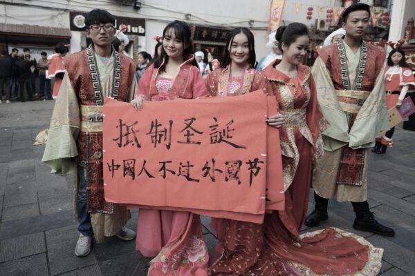 University students wearing traditional Chinese outfits hold banners reading "Resist Christmas, Chinese people should not celebrate foreign festivals" in Changsha, central China's Hunan Province, during an anti-Christmas street protest on Dec. 24, 2014. (STR/AFP via Getty Images)