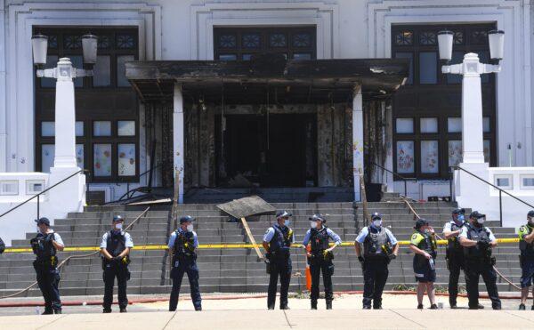 Police officers stand guard outside the fire-damaged entrance to Old Parliament House in Canberra, Australia, on Dec. 30, 2021. (AAP Image/Lukas Coch)