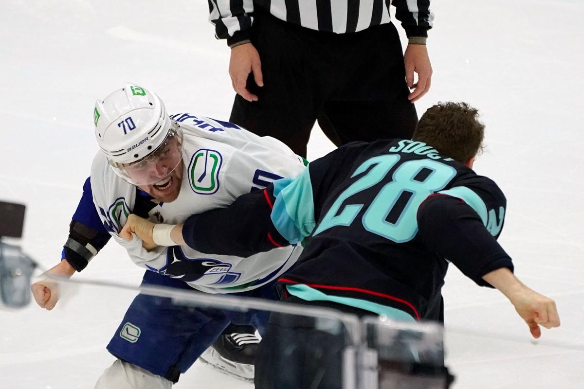 Vancouver Canucks left wing Tanner Pearson (L) fights with Seattle Kraken defenseman Carson Soucy (R) during the first period of an NHL hockey game in Seattle on Jan. 1, 2022. (Ted S. Warren/AP Photo)