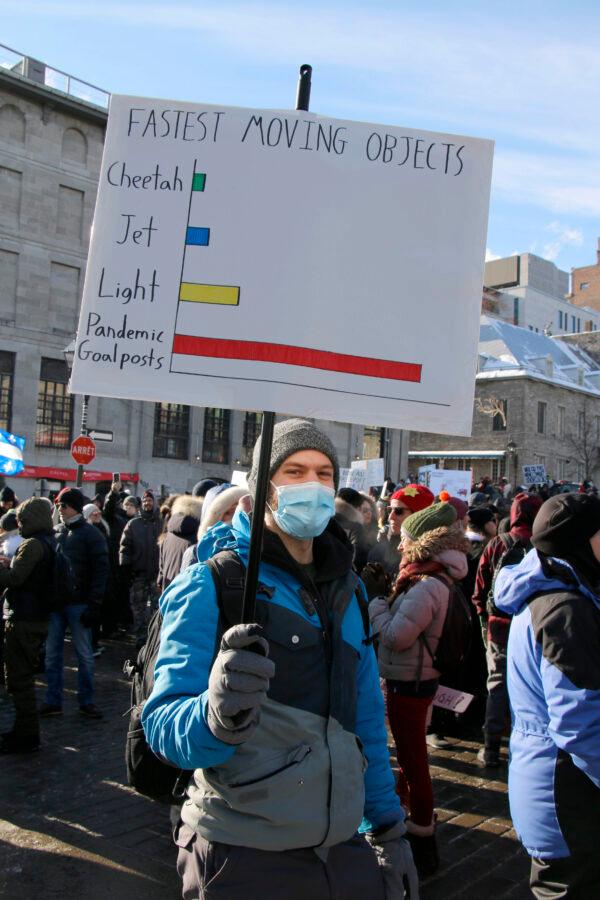 A protester carries a placard during a march against restrictive pandemic policies in Montreal on Jan. 8, 2022. (Noé Chartier/The Epoch TImes)