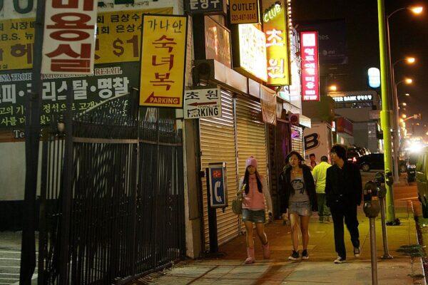 Young people walk past shuttered businesses outside of the trendy section of Koreatown in Los Angeles, Calif., on Oct. 31, 2006. (David McNew/Getty Images)