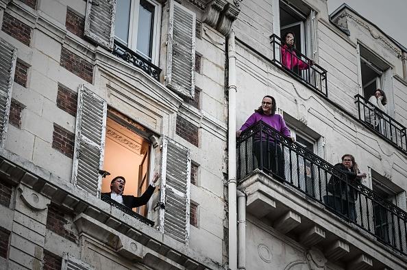 TOPSHOT - French opera tenor singer Stephane Senechal performs the song O sole mio from his window in Paris on March 26, 2020 on the evening of the tenth day of a strict lockdown in France. (Photo by PHILIPPE LOPEZ/AFP via Getty Images)