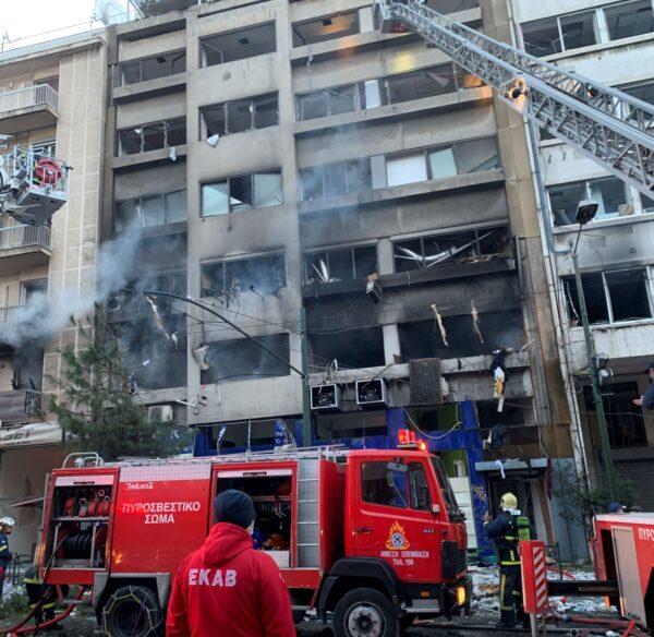 Firefighters use aerial ladders to look for anyone possibly trapped inside damaged buildings following an explosion in central Athens, Greece, on Jan. 26, 2022. (Derek Gatopoulos/AP Photo)