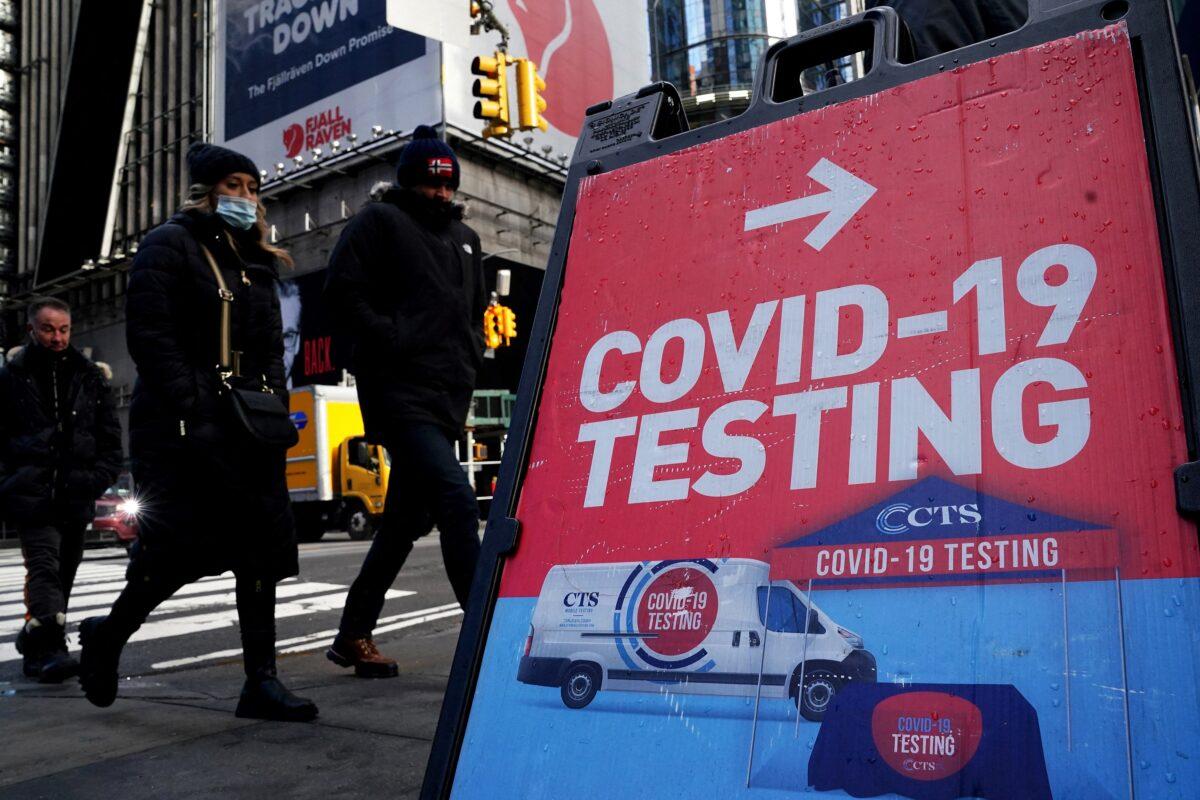 People walk past a COVID-19 testing sign in the Manhattan borough of New York on Jan. 20, 2022. (Carlo Allegri/Reuters)