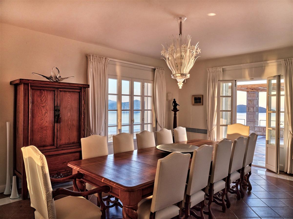 The formal dining room, like most of the villa’s spaces, has spellbinding views of the sea as well as access to the terraces and grounds. (Courtesy of Greece Sotheby's International Realty)