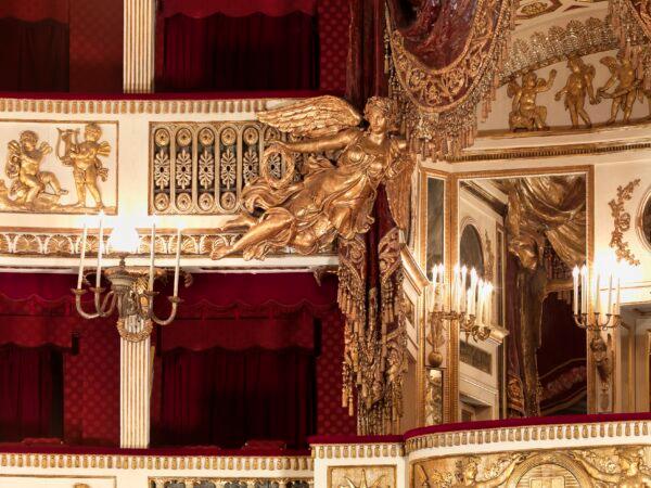 Angels fly with wreaths and hold open drapery to reveal those in the royal box to the patrons in the auditorium. (Luciano Romano/Teatro di San Carlo)