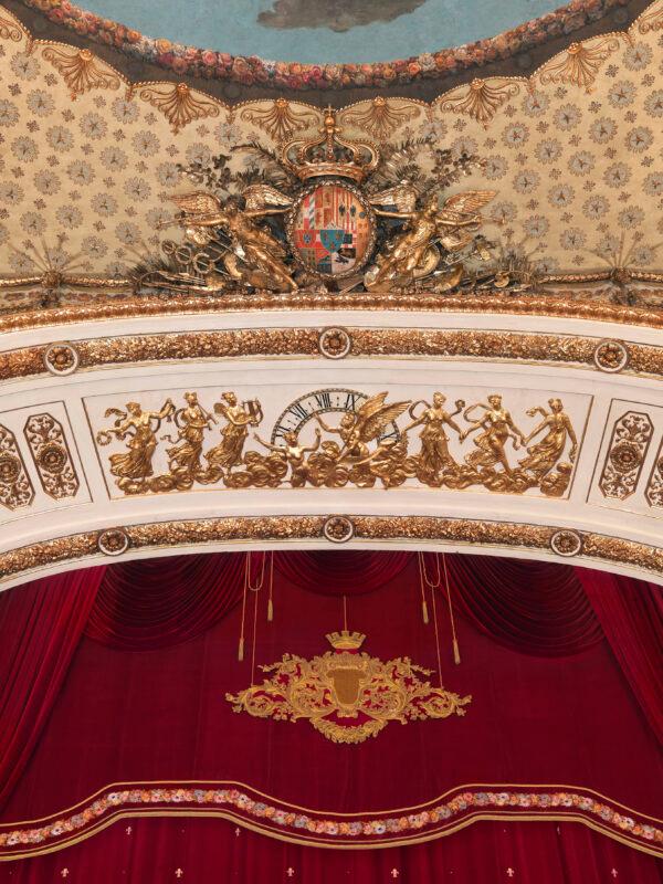 At the center of the proscenium arch, a whimsical scene plays out where, in gold, maidens of music and dance are afloat on clouds. Above them, angels sound trumpets to present the royal emblem. (Luciano Romano/Teatro di San Carlo)
