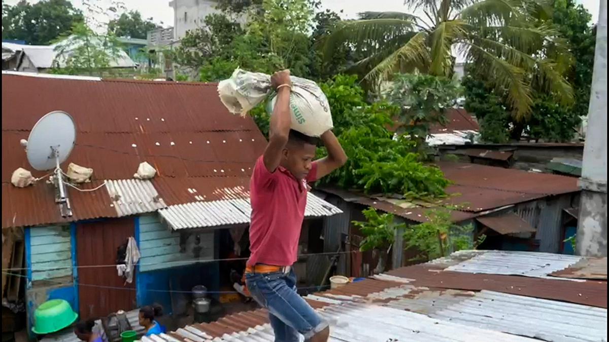 A man carries a sandbag to secure his tin roof in Toamasina, on Feb. 4, 2022, as he prepares for Tropical Cyclone Batsirai to make landfall in central Madagascar. (AP Photo)
