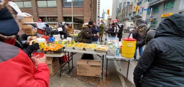 Volunteers provide free food and drinks as protests against COVID-19 mandates and restrictions continue in Ottawa on Feb. 6, 2022. (NTD)