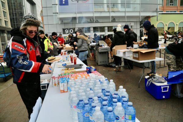 Volunteers serve food and drinks to protesters demonstrating against COVID-19 mandates and restrictions in Ottawa on Feb. 9, 2022. (Jonathan Ren/The Epoch Times)