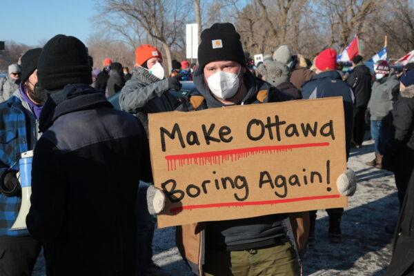 One of many signs being held by Ottawa residents at an ambush of vehicles heading toward the truckers blockade on Feb. 13, 2022. (Richard Moore/The Epoch Times)