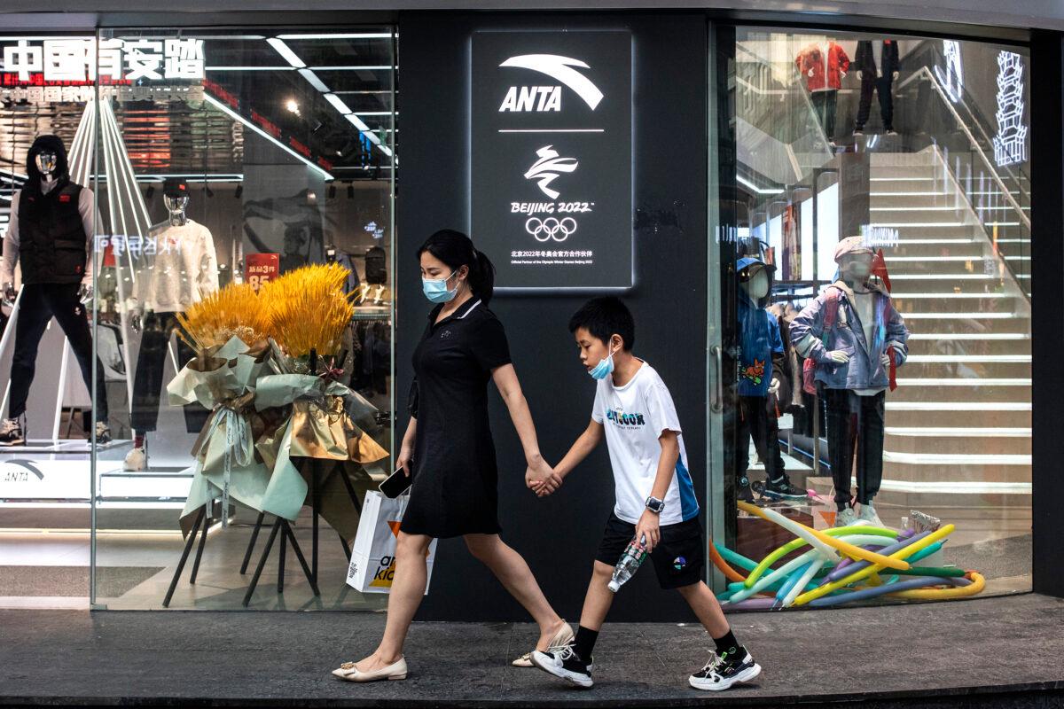 People wear masks while walking through the ANTA of Beijing winter Olympic partner store in Wuhan, Hubei Province, China, on Oct. 3, 2021. (Getty Images)