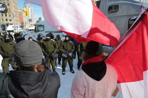 A face-off between protesters and police in Ottawa on Feb. 18, 2022. (Richard Moore/The Epoch Times)