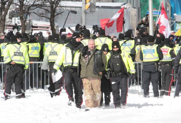 A person is arrested in Ottawa on Feb. 18, 2022. (Richard Moore/The Epoch Times)
