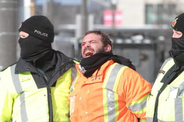 A trucker is arrested in Ottawa on Feb. 18, 2022. (Richard Moore/The Epoch Times)
