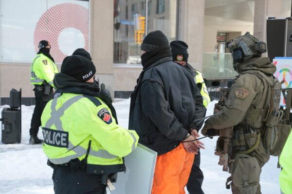 A person is arrested in Ottawa on Feb. 18, 2022. (Richard Moore/The Epoch Times)