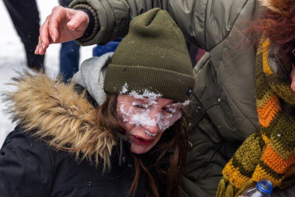 A woman washers her eyes with snow after being pepper sprayed in Ottawa as police continue to push back protesters in Ottawa on Feb. 19, 2022. (Alex Kent/Getty Images)