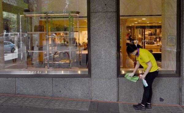 A cleaner wipes the front of a Gucci store in Melbourne, Australia, on Oct. 28, 2021. (William West/AFP via Getty Images)