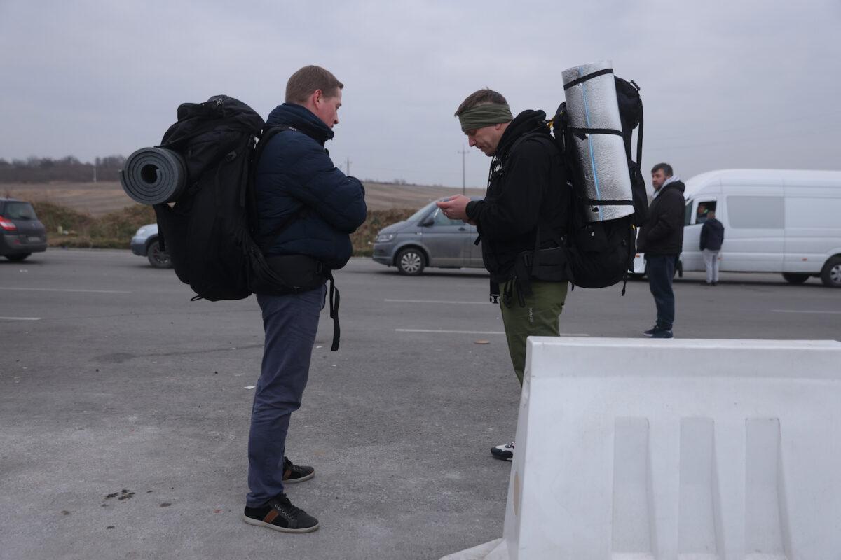 Volodomyr (R), 46, and Vitaly, 44, both Ukrainians who live abroad, arrive to cross into Ukraine to join the armed forces fighting against the invading Russian army at the Medyka border crossing in Medyka, Poland, on March 4, 2022. (Sean Gallup/Getty Images)