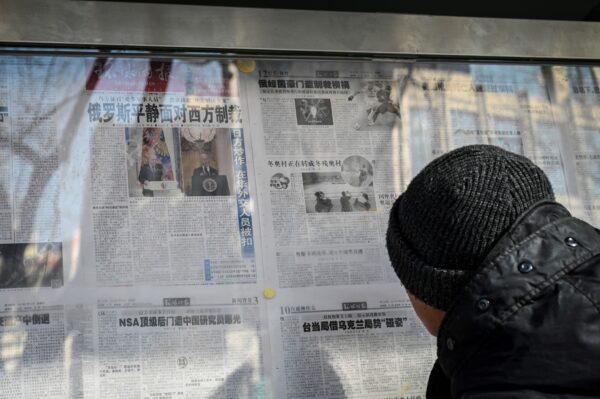 A man reads the Chinese state-run newspaper with coverage of the conflict between Russia and Ukraine, on a street in Beijing, China, on Feb. 24, 2022. (Jade Gao/AFP via Getty Images)