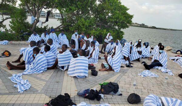 Haitian migrants on shore wrapped in towels after a boat ran aground in the Florida Keys off Key Largo, on March 6, 2022. (United States Border Patrol via AP)