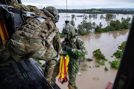 Australian Army aircrewman prepares to conduct a rescue by winch of a community member from an MRH-90 Taipan, over Lismore, Australia, on Feb. 28, 2022. (Australian Defence Force)