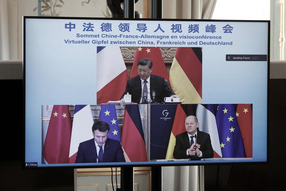 A video screen displays French President Emmanuel Macron (bottom left), German Chancellor Olaf Scholz (bottom right), and Chinese leader Xi Jinping (top) attending a video conference to discuss the Ukraine crisis at the Elysee Palace in Paris, on March 8, 2022. (Benoit Tessier/AFP via Getty Images)