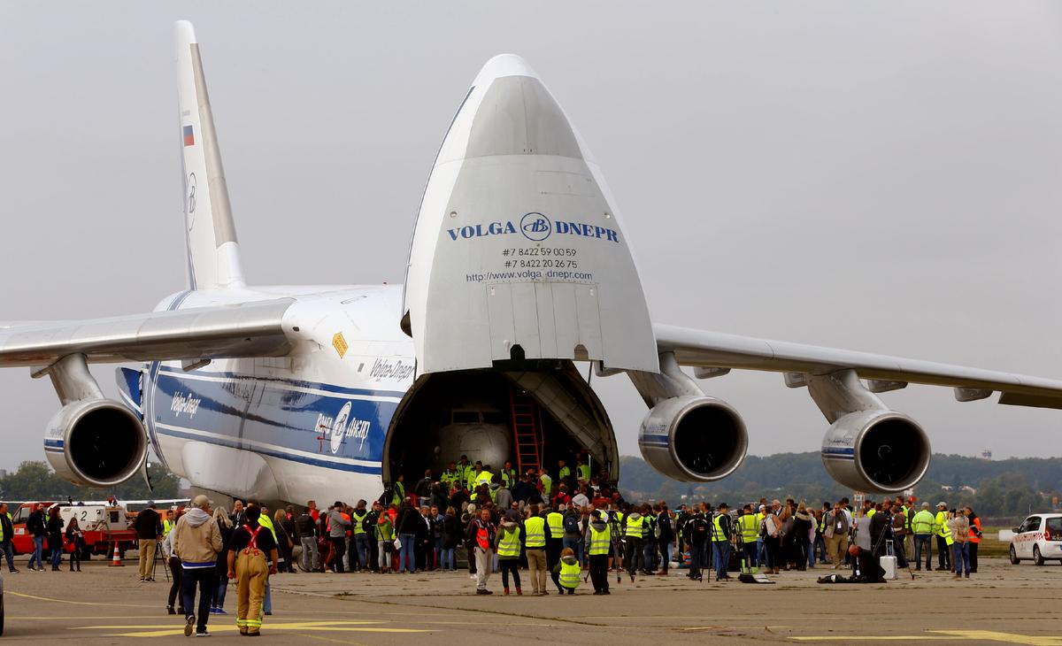 People stand in front of a Russian Volga-Dnepr Airlines Antonov An-124 aircraft transporting the fuselage of a Lufthansa Boeing 737-200, also known as Landshut, after its arrival at the airport in Friedrichshafen, Germany, on Sept. 23, 2017. (Arnd Wiegmann/Reuters)