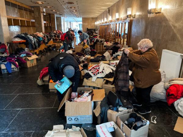 People sort through donated goods inside the opera house in Ivano-Frankivsk, Ukraine, on March 20, 2022. (Charlotte Cuthbertson/The Epoch Times)