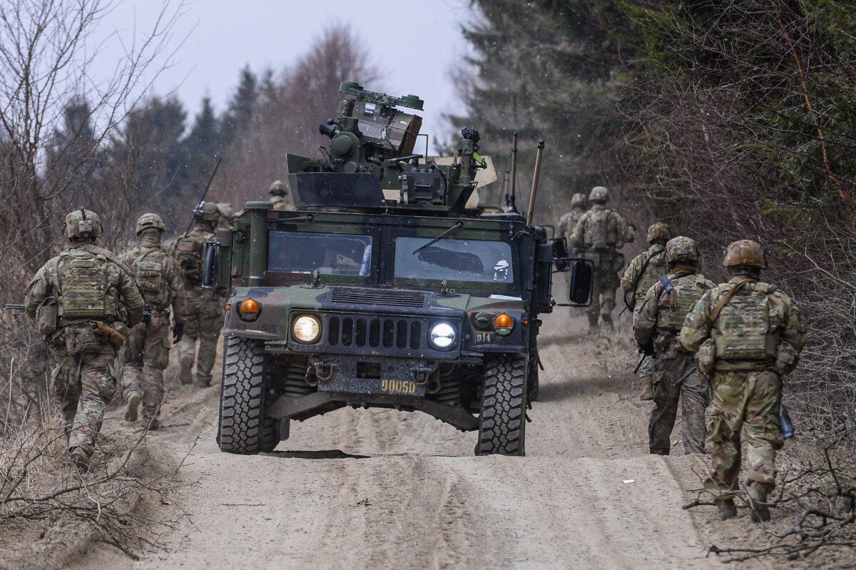 U.S. Army soldiers assigned to the 82nd Airborne carry military equipment as they take part in a exercise outside the operating base at the Arlamow Airport in Wola Korzeniecka, Poland. (Omar Marques/Getty Images)