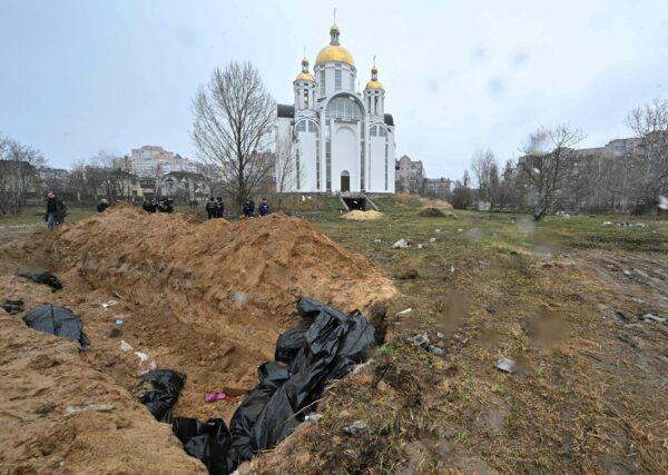 A mass grave is seen behind a church in the town of Bucha, northwest of the Ukrainian capital Kyiv on April 3, 2022. (Sergei SUPINSKY/AFP via Getty Images)