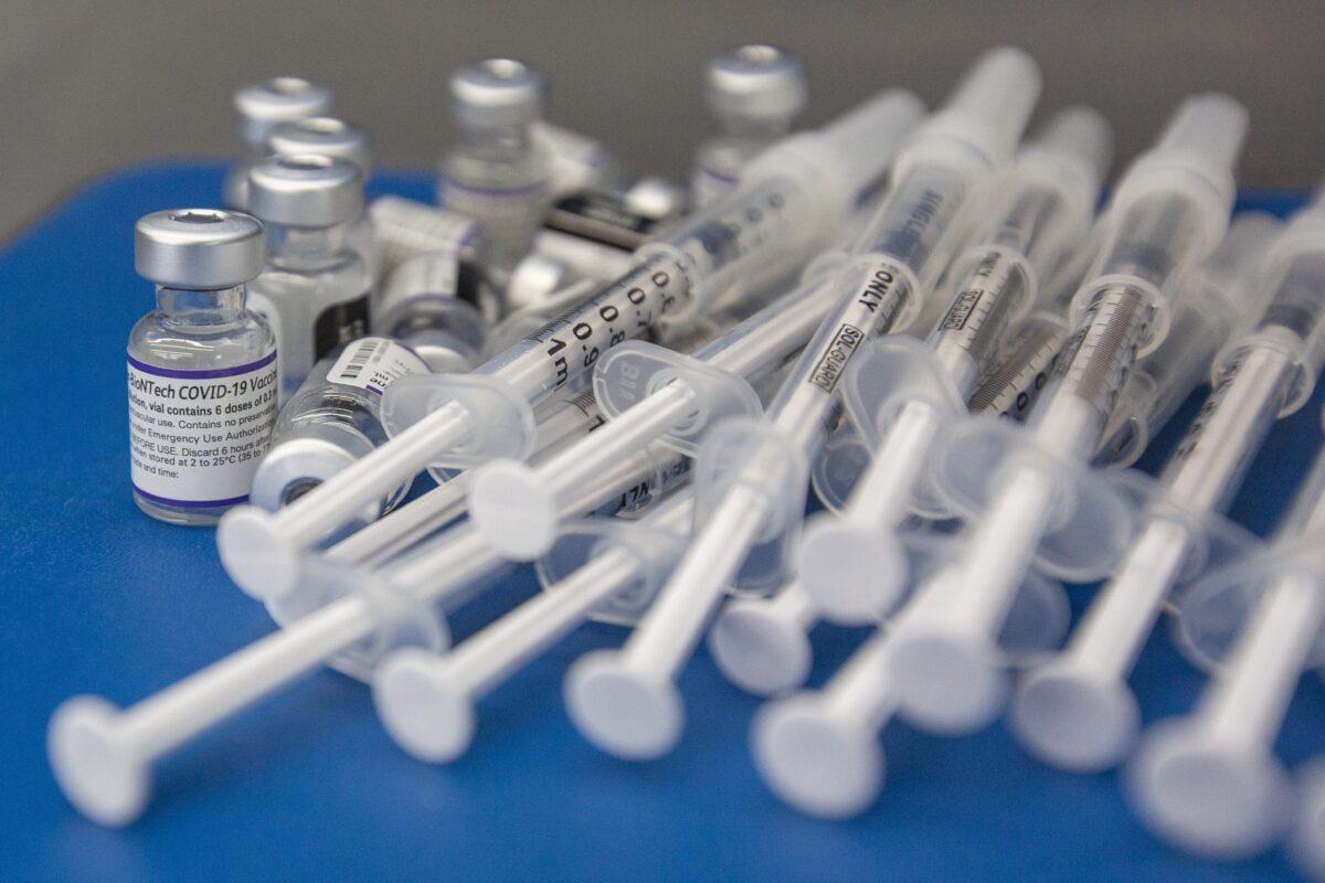 Syringes and vials of Pfizer-BioNTech COVID-19 vaccine on a work surface during a drive-through clinic at St. Lawrence College in Kingston, Ontario, on Dec. 18, 2021. (The Canadian Press/Lars Hagberg)