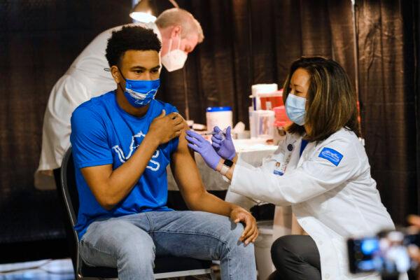 A group of teenagers receives a dose of the Pfizer COVID vaccine in Detroit on April 6, 2021. (Matthew Hatcher/Getty Images)