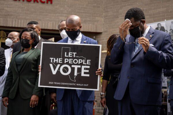 Members of the Texas Legislative Black Caucus bow their heads in prayer with local faith leaders at the end of a news conference about voting rights at Unity Baptist Church in Washington on July 26, 2021. (Drew Angerer/Getty Images)