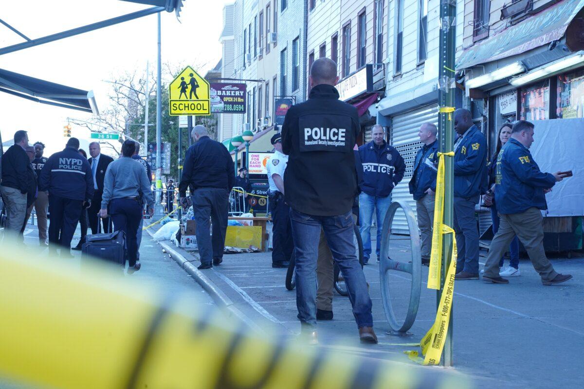 Officers investigate a shooting at the 36th Street subway station in Brooklyn on April 12, 2022. (Enrico Trigoso/The Epoch Times)