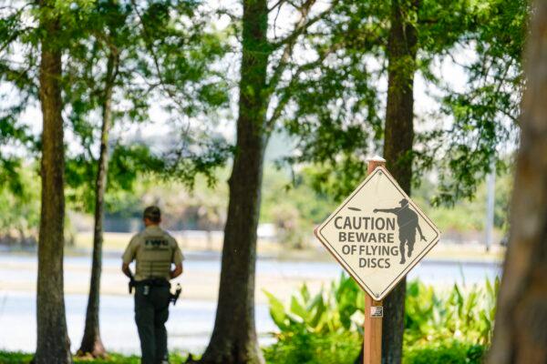 A Florida Fish and Wildlife Conservation Commission officers stands by a lake in John S. Taylor Park, where a man was found dead, in Largo, Fla., on May 31, 2022. (Martha Asencio-Rhine/Tampa Bay Times via AP)