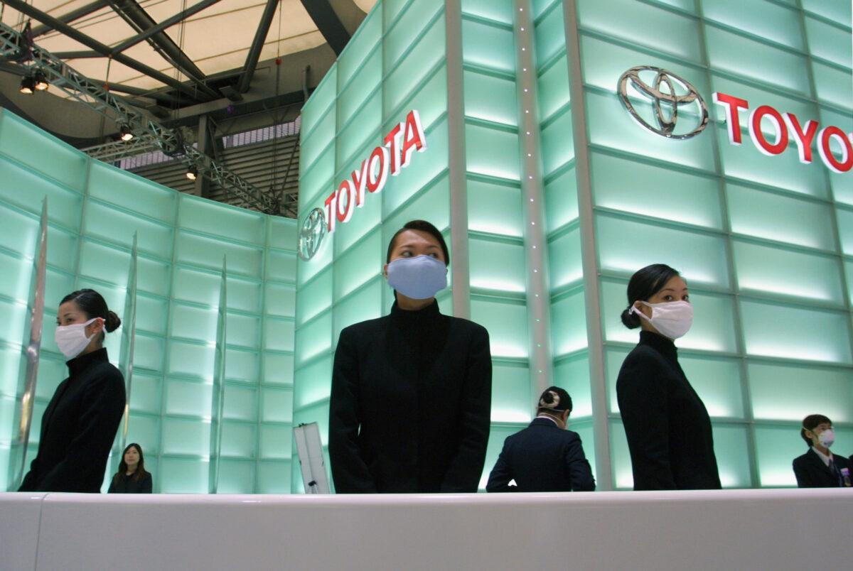 Chinese employees from Toyota wear masks to protect against Severe Acute Respiratory Syndrome (SARS) while waiting to serve customers at the International Auto and Manufacturing Technology Exhibition, Shanghai 2003, on April 20, 2003. (Severe Acute Respiratory Syndrome).