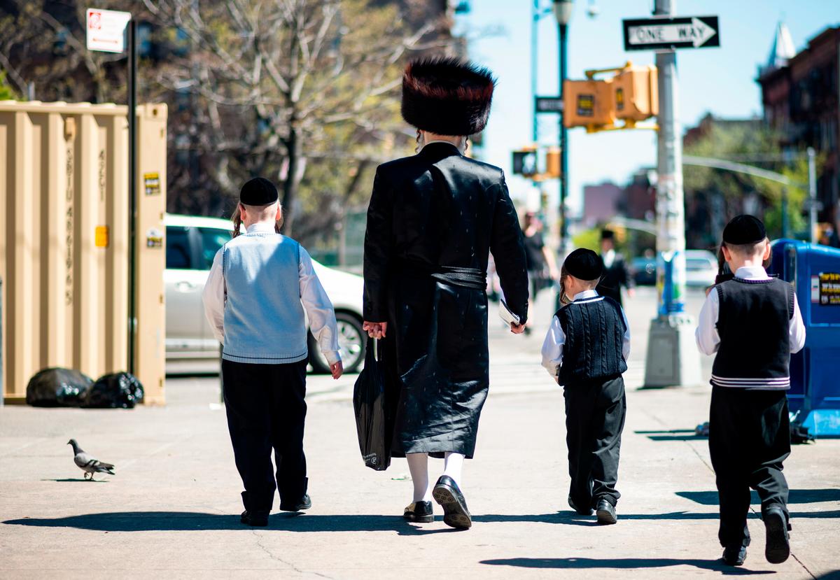 A Jewish man and his three sons walk down a street in a Jewish quarter in Williamsburg Brooklyn in New York City on April 24, 2019. (JOHANNES EISELE/AFP via Getty Images)