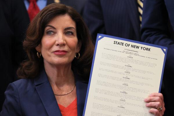New York Gov. Kathy Hochul holds up signed legislation during a ceremony at the Bronx YMCA in New York on June 6, 2022. (Michael M. Santiago/Getty Images)