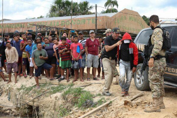 Federal Police officers escort a man accused to be involved in the missing of British journalist Dom Phillips and indigenous expert Bruno Pereira in Atalaia do Norte, Amazonas state, Brazil, on June 15, 2022. (Bruno Kelly/Reuters)