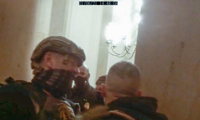 An Oath Keepers member gets in between a protester and a Capitol Police officer during a tense exchange in the Small House Rotunda on Jan. 6, 2021. (Stephen Horn/Screenshot via The Epoch Times)