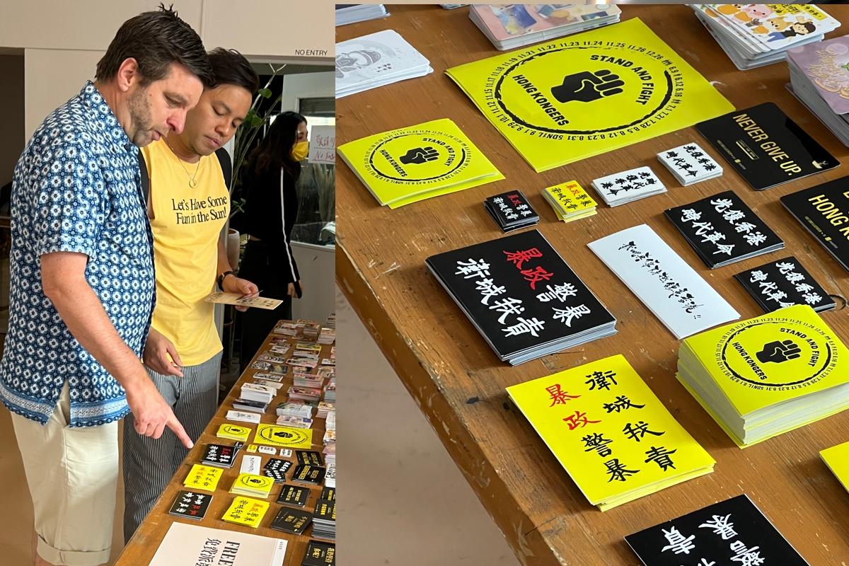 Many promotional cards, shipped from Hong Kong and printed with messages of anti-extradition and protest slogans, are placed at the entrance for the visitors to take home. (Angela Chen/The Epoch Times UK)