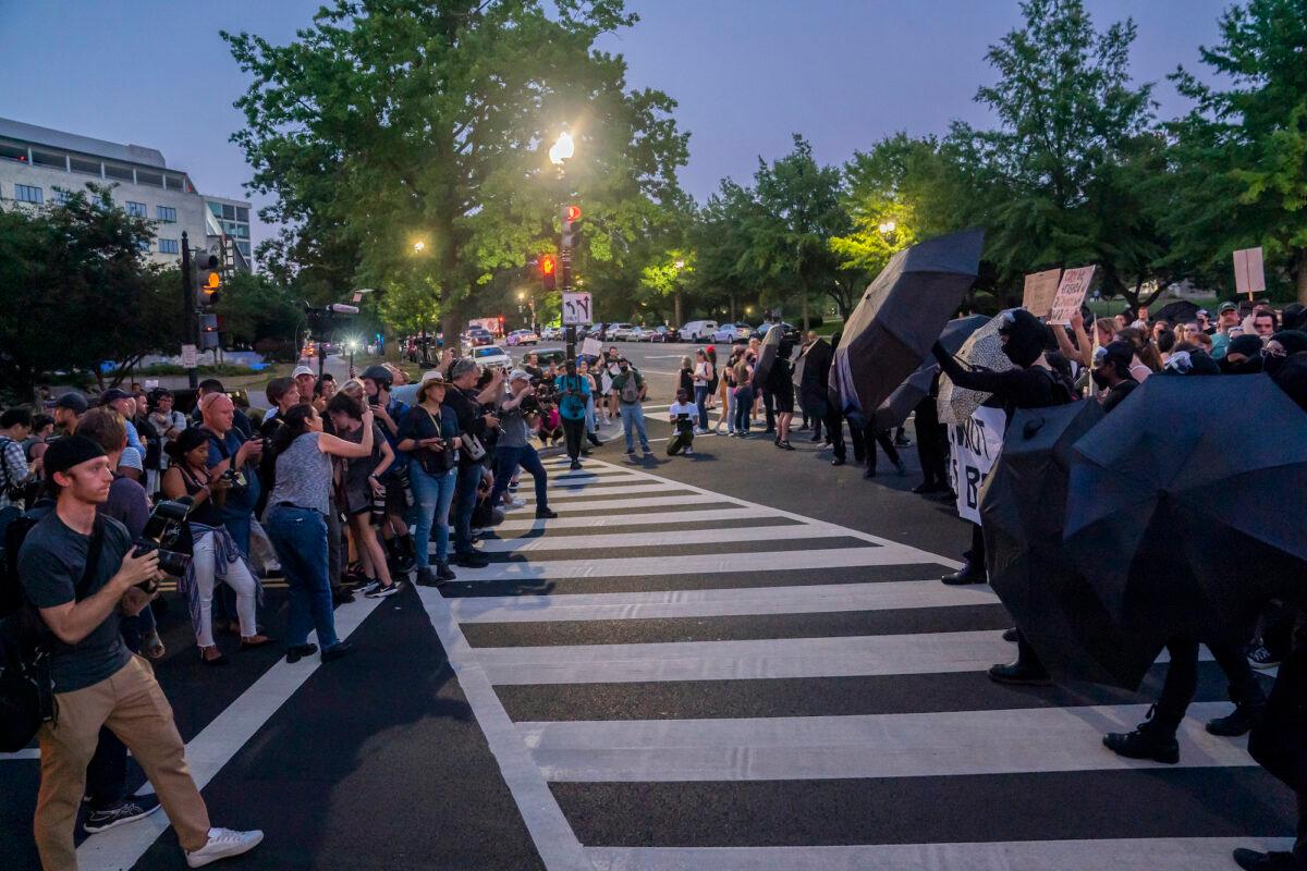 Pro-abortion protesters block cameras with umbrellas as they gather in protest in Washington, on June 24, 2022. (Nathan Howard/Getty Images)