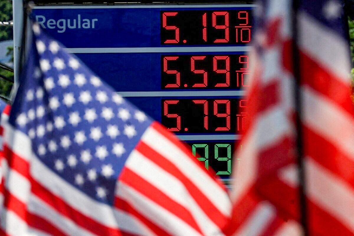 Gasoline prices at an Exxon gas station behind an American flag in Edgewater, N.J., on June 14, 2022. (Mike Segar/Reuters)