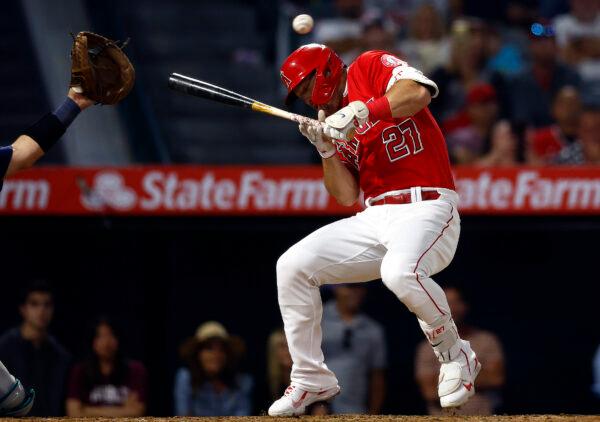 Mike Trout #27 of the Los Angeles Angels dodges a foul ball against the Seattle Mariners at Angel Stadium in Anaheim, Calif., on June 25, 2022. (Ronald Martinez/Getty Images)
