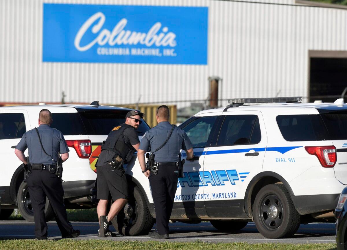 Police stand near where a man killed three people when he opened fire at a business in Smithsburg, Md., on June 9, 2022. (Steve Ruark/AP Photo)