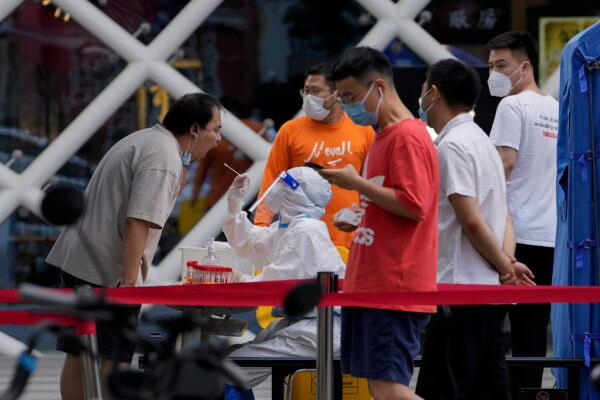 Residents get swabbed during mass COVID-19 testing in the Chaoyang District in Beijing on June 14, 2022. (Andy Wong/AP Photo)