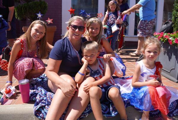 Allyson Grimet (2nd L) with her children at the Independence Day parade in downtown Fairfax, Va., on July 4, 2022. (Terri Wu/The Epoch Times)