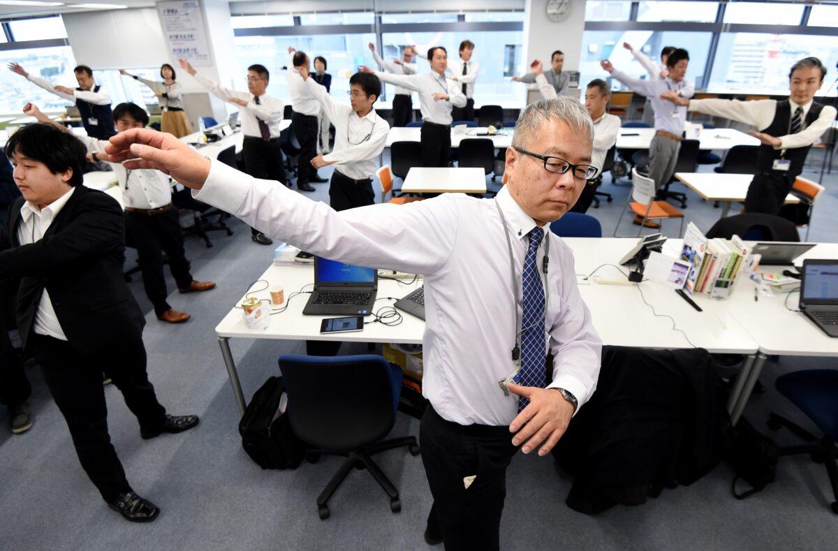 Employees of an information technology company exercising together in their office after lunchtime in Tokyo, on November 10, 2016. (Toru Yamanaka/AFP via Getty Images)