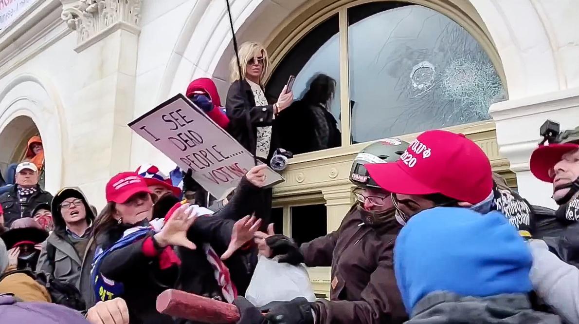 Victoria White lunged to grab a club from a protester as the crowd shouted "[expletive] Antifa!" at the U.S. Capitol on Jan. 6, 2021. (Screenshot via The Epoch Times)